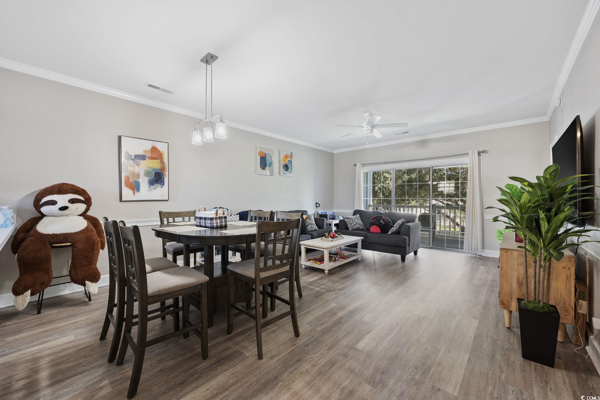 4639 Wild Iris Drive, Unit 203 Myrtle Beach, SC 29577 - Photo 13 of 30 Dining space with ornamental molding, light wood-style flooring, and a ceiling fan