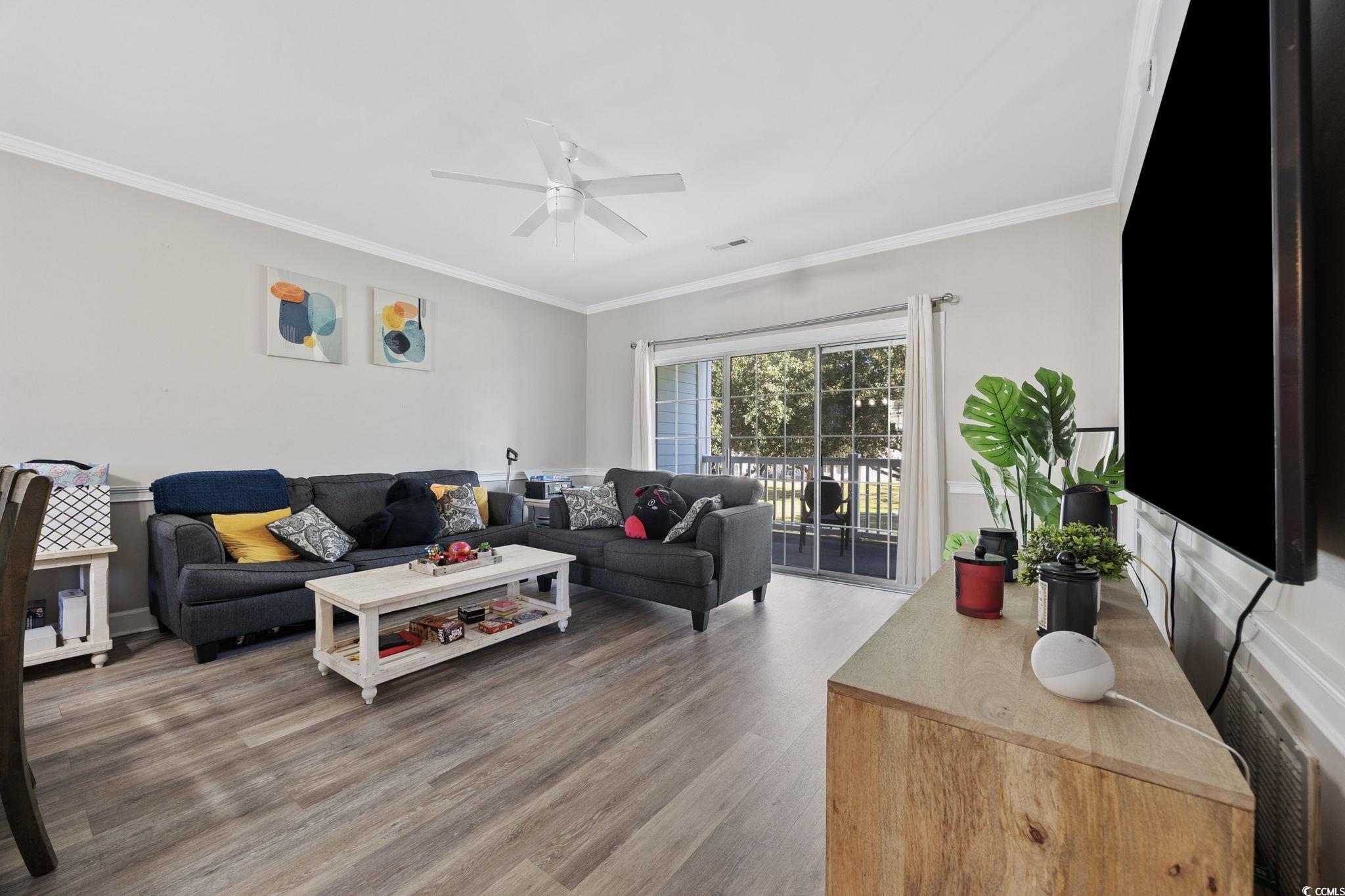 4639 Wild Iris Drive, Unit 203 Myrtle Beach, SC 29577 - Photo 14 of 30 Living area with crown molding, light wood finished floors, and ceiling fan