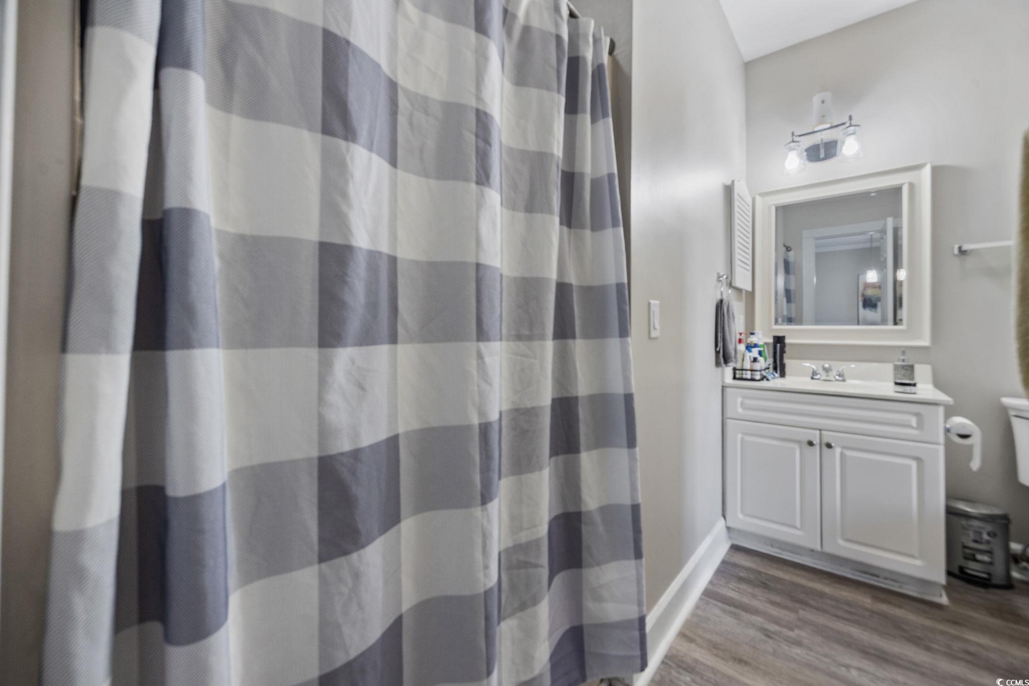 4639 Wild Iris Drive, Unit 203 Myrtle Beach, SC 29577 - Photo 16 of 30 Bathroom with curtained shower, vanity, and light wood-type flooring