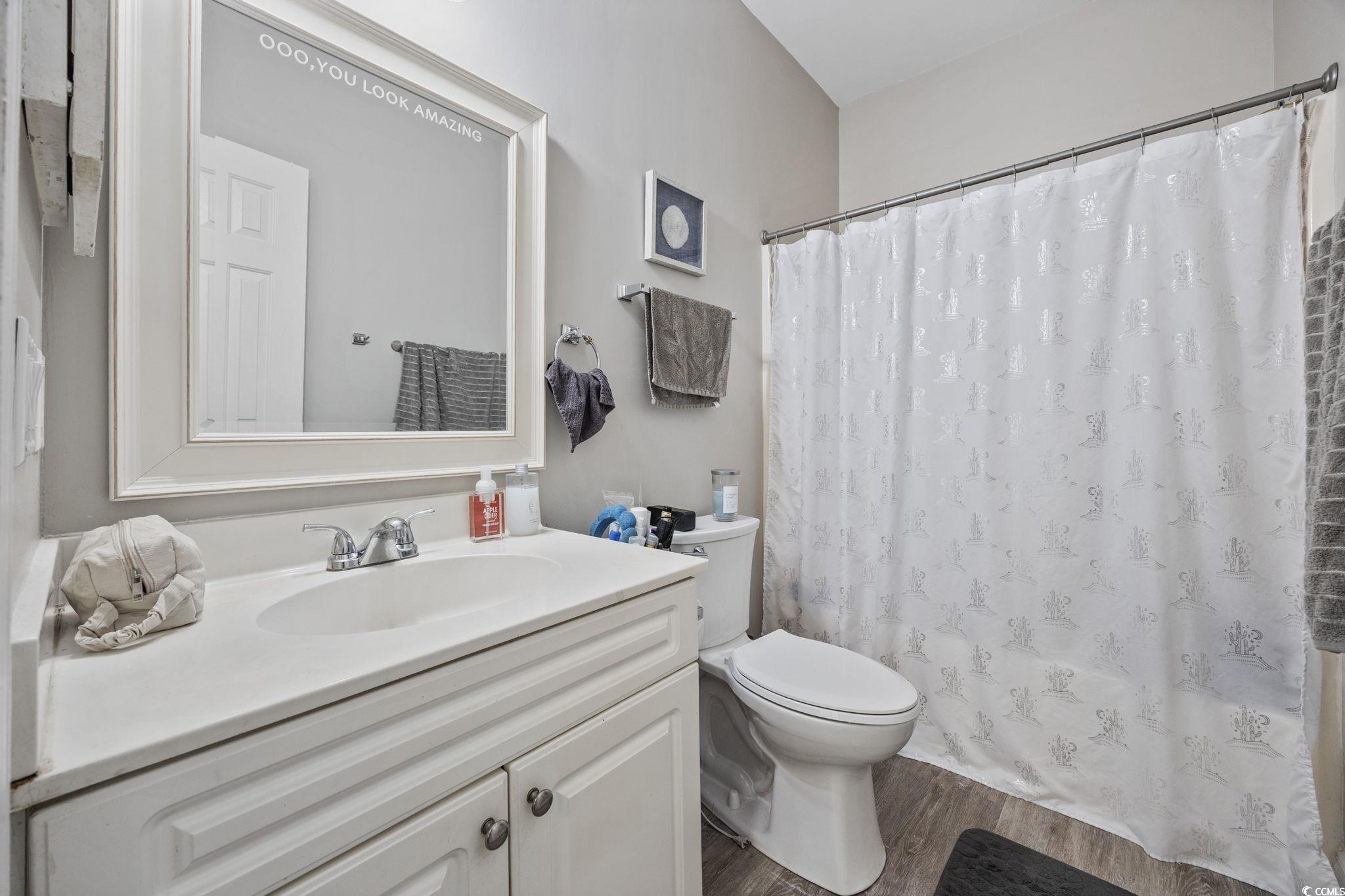 4639 Wild Iris Drive, Unit 203 Myrtle Beach, SC 29577 - Photo 20 of 30 Full bathroom featuring vanity, dark wood-style flooring, and shower / bath combo with shower curtain