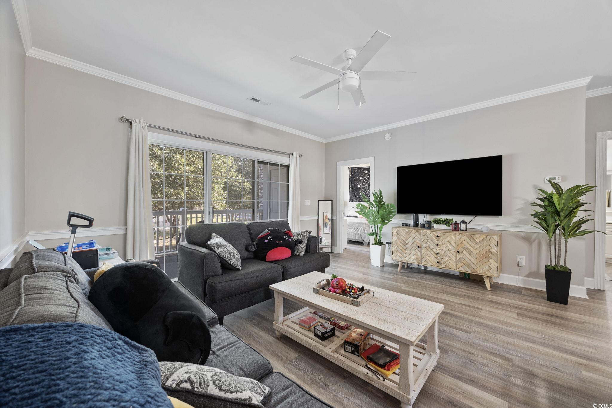 4639 Wild Iris Drive, Unit 203 Myrtle Beach, SC 29577 - Photo 6 of 30 Living room with ornamental molding, wood finished floors, and ceiling fan