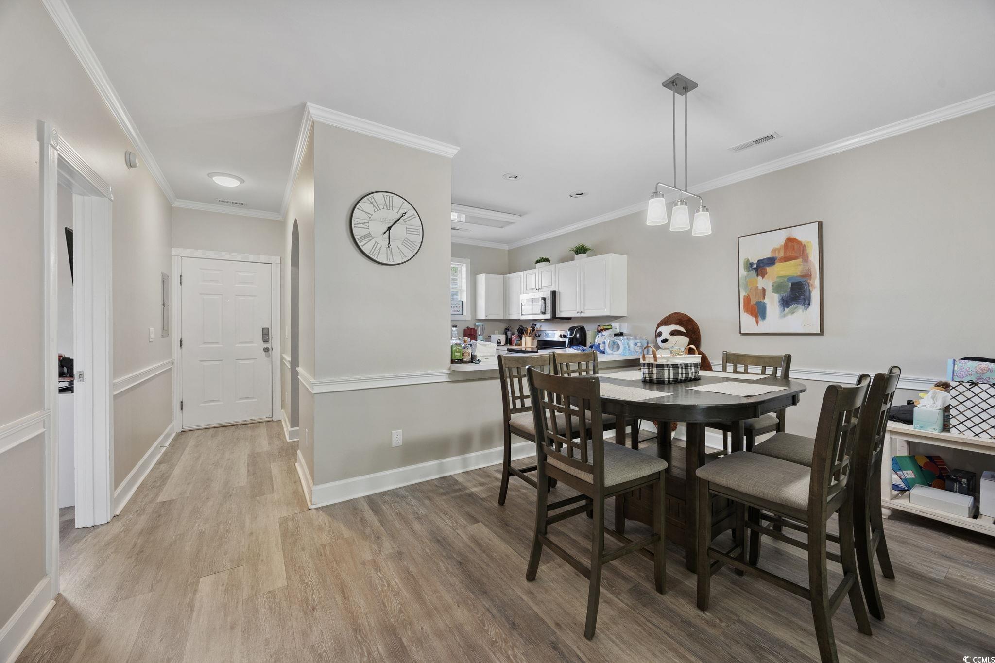 4639 Wild Iris Drive, Unit 203 Myrtle Beach, SC 29577 - Photo 8 of 30 Dining area with crown molding and light wood-type flooring