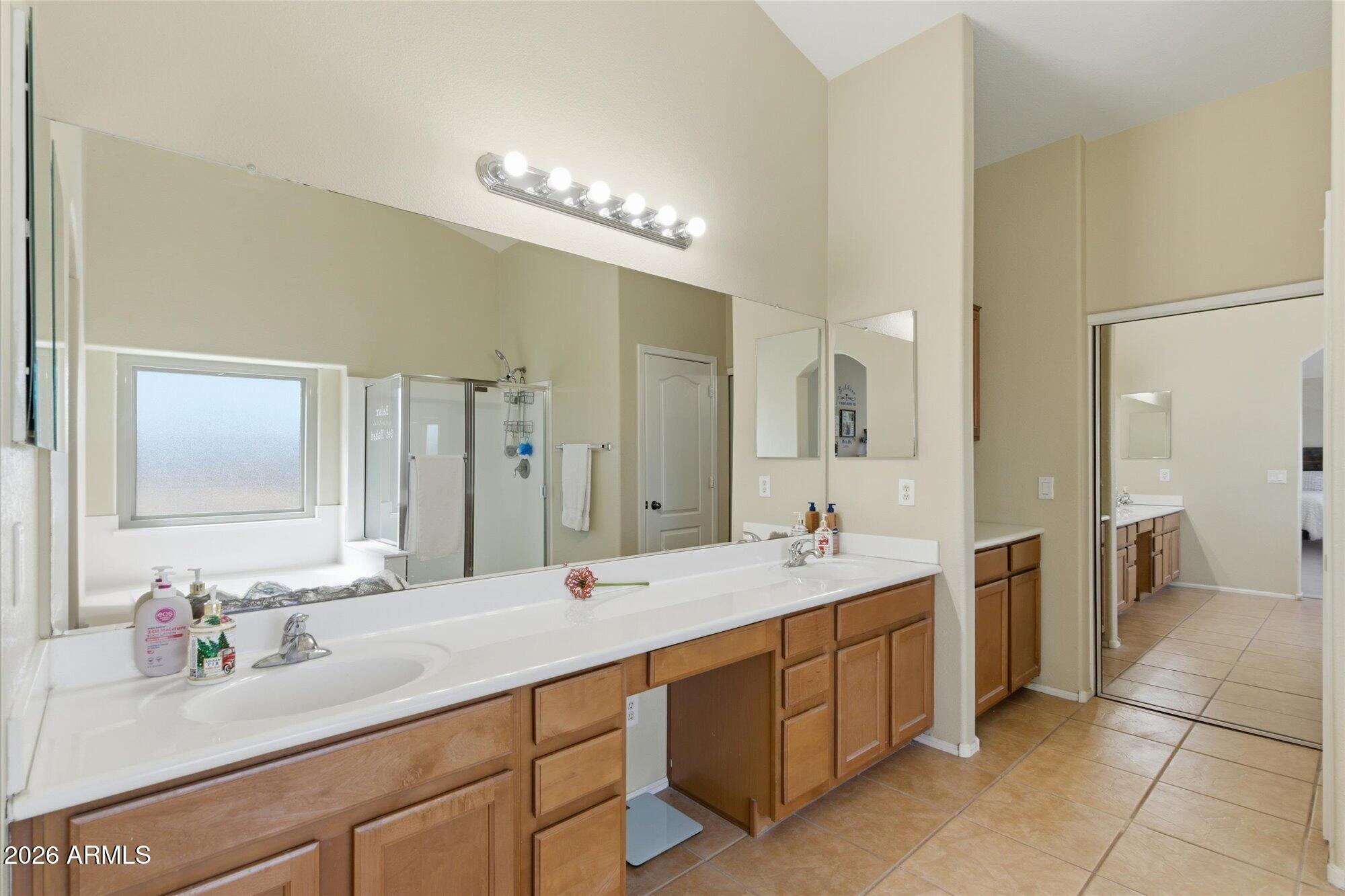 21915 Dietz Drive Maricopa, AZ 85138 - Photo 19 of 31 a bathroom with a double vanity sink a mirror and a shower