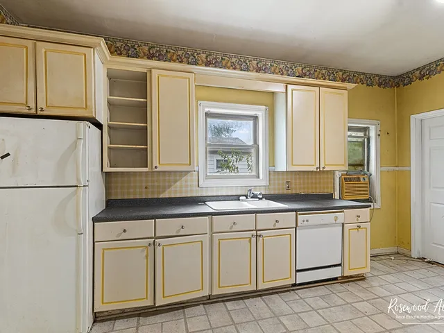 a kitchen with white cabinets and white appliances
