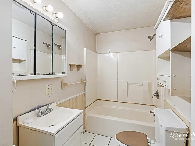 a bathroom with a tub sink and a mirror