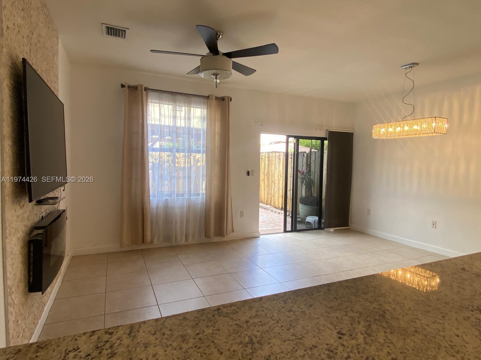 11543 Southwest 248th Lane Homestead, FL 33032 - Photo 11 of 32 a view of an empty room with a fireplace and a window