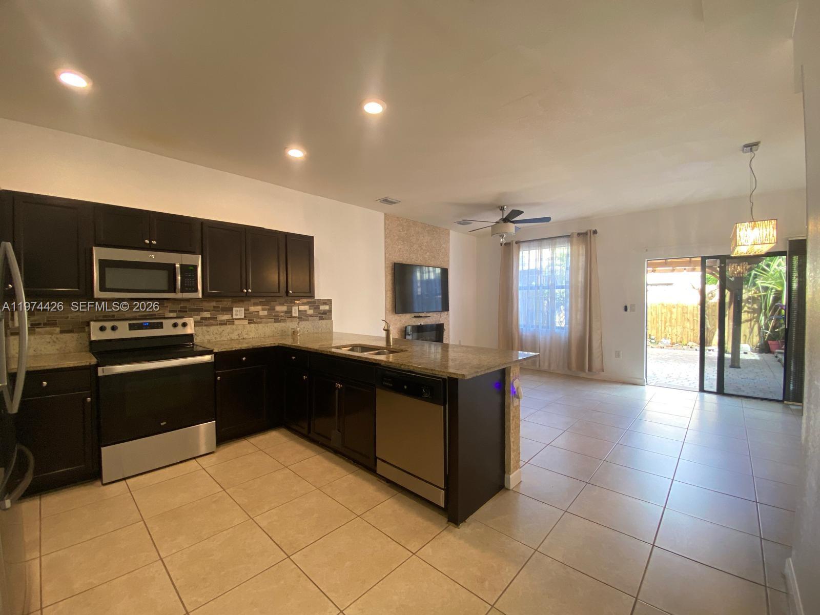 11543 Southwest 248th Lane Homestead, FL 33032 - Photo 2 of 32 a large kitchen with a large counter top appliances and cabinets