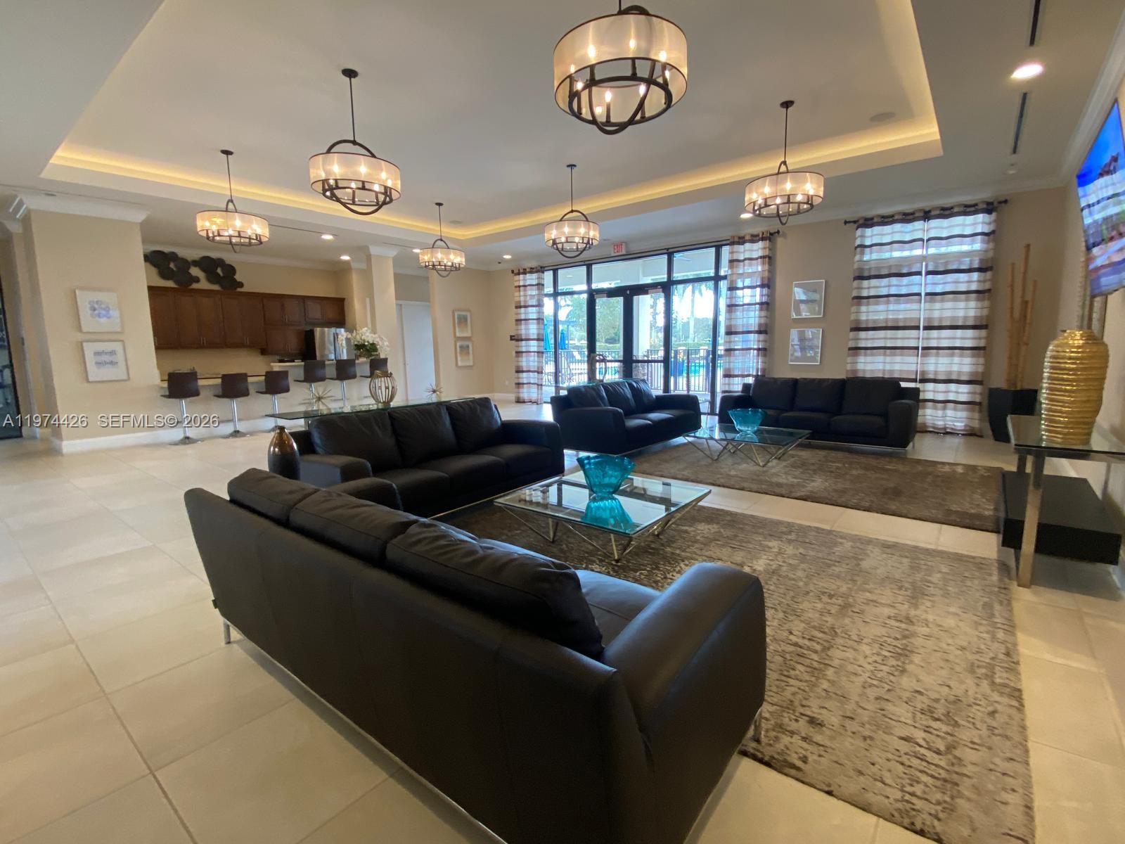 11543 Southwest 248th Lane Homestead, FL 33032 - Photo 27 of 32 a living room with furniture a large window and a chandelier