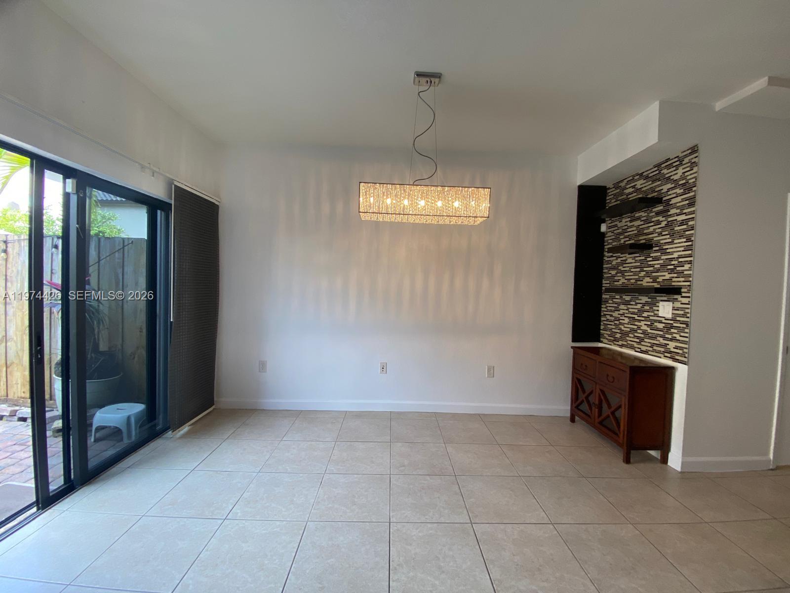11543 Southwest 248th Lane Homestead, FL 33032 - Photo 6 of 32 an empty room with fireplace and windows