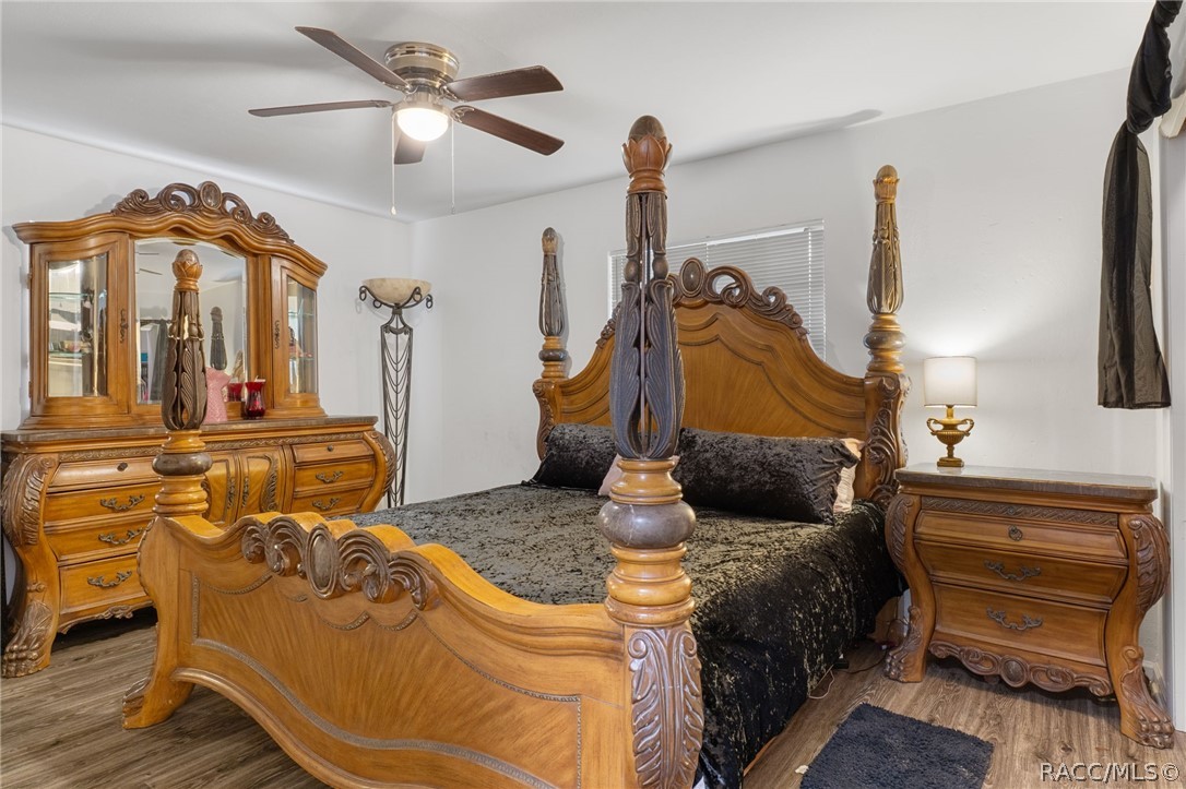 1140 South Highlands Avenue Inverness, FL 34452 - Photo 28 of 54 a bedroom with a bed and dresser with wooden floor