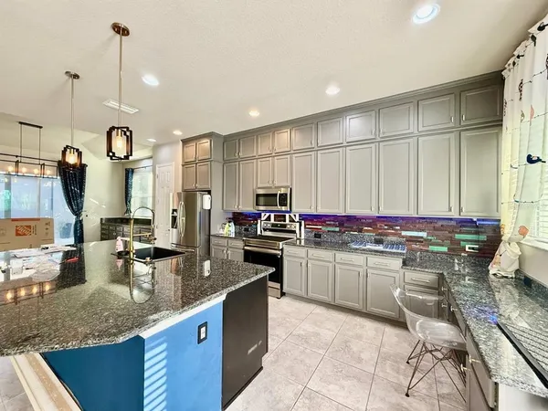 a kitchen with granite countertop a sink counter top space and appliances