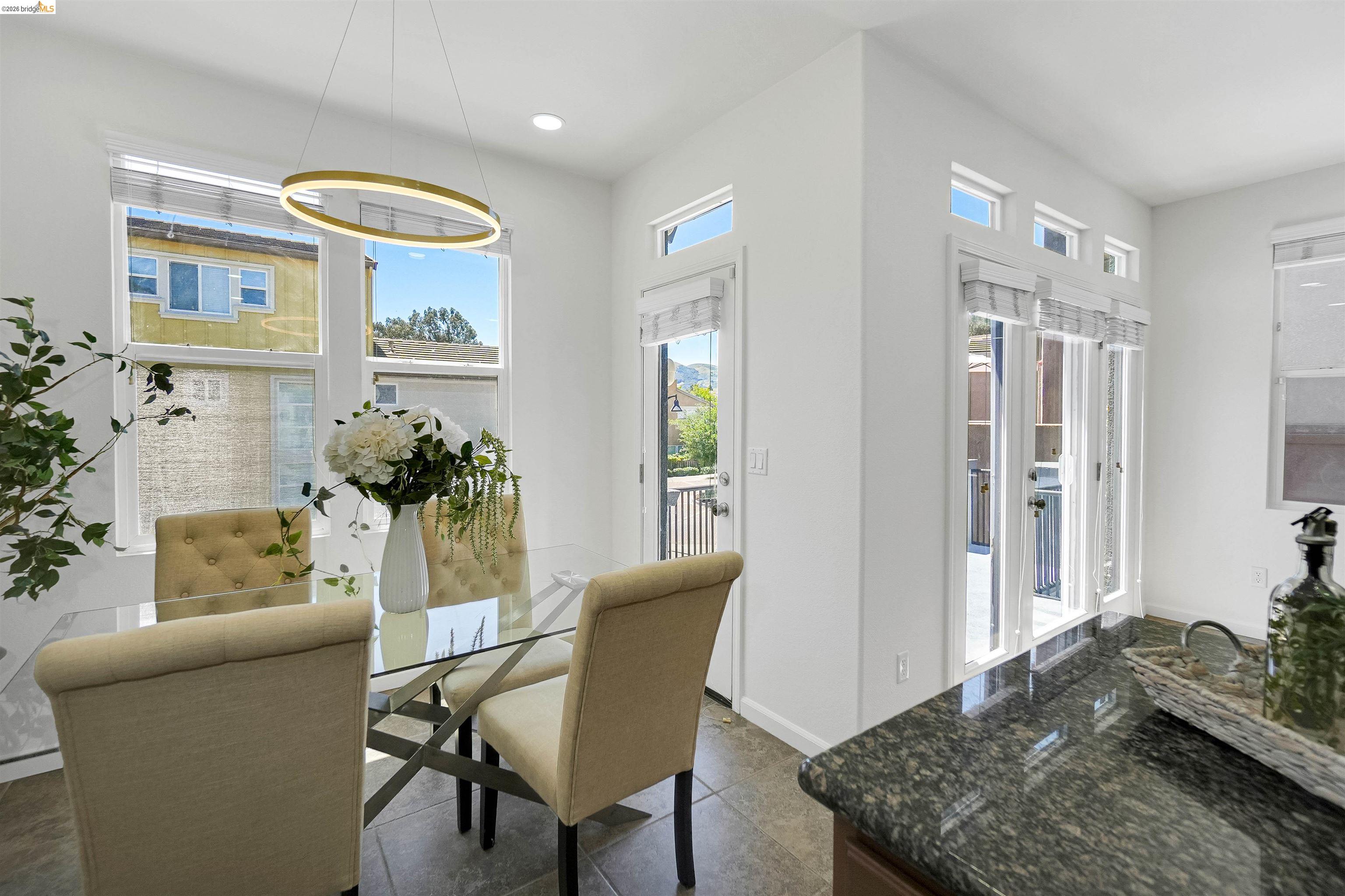 449 Constantine Court San Ramon, CA 94583 - Photo 24 of 63 Dining area with a modern circular chandelier, multiple windows, French doors, and stone tile flooring