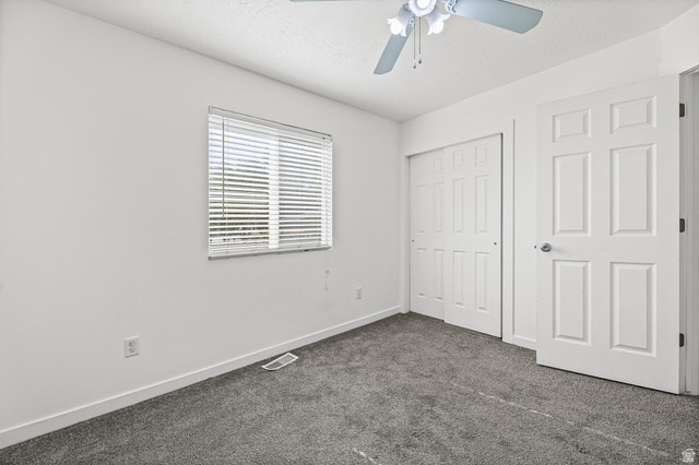 5525 Hampton Way Stansbury Park, UT 84074 - Photo 14 of 35 Bright room featuring gray carpet flooring, white walls, and a ceiling fan with light fixture