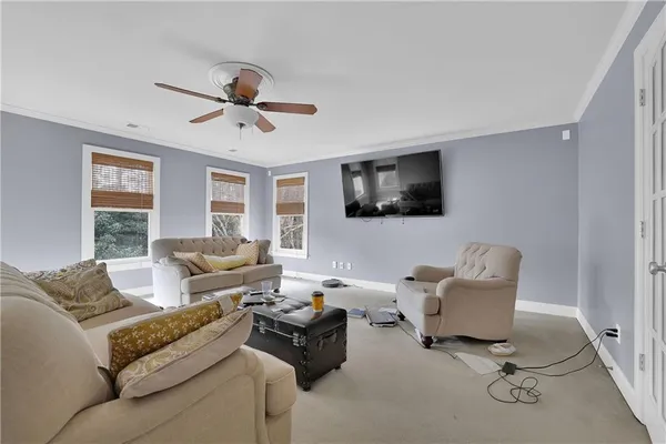 a living room with furniture ceiling fan and a window