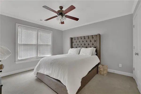 a large bed sitting in a bedroom next to a window