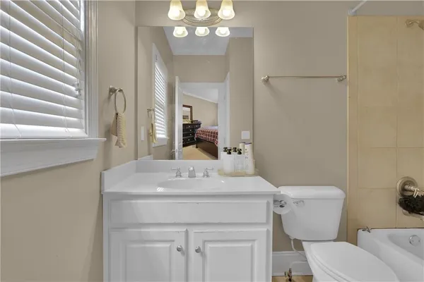 a bathroom with a sink a toilet a mirror and shower curtain