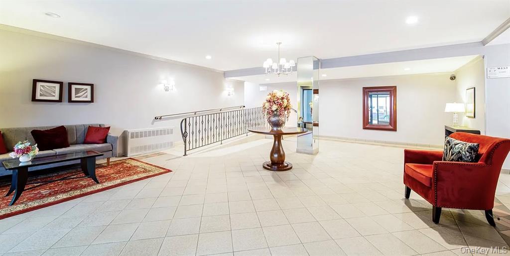 241-20 Northern Boulevard, Unit 4C Queens, NY 11362 - Photo 11 of 12 a living room with furniture and a chandelier