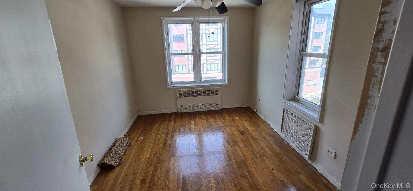 241-20 Northern Boulevard, Unit 4C Queens, NY 11362 - Photo 9 of 12 wooden floor in an empty room with a window