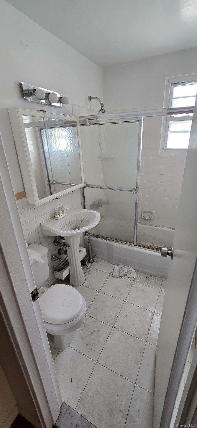 241-20 Northern Boulevard, Unit 4C Queens, NY 11362 - Photo 10 of 12 a bathroom with a sink toilet and shower