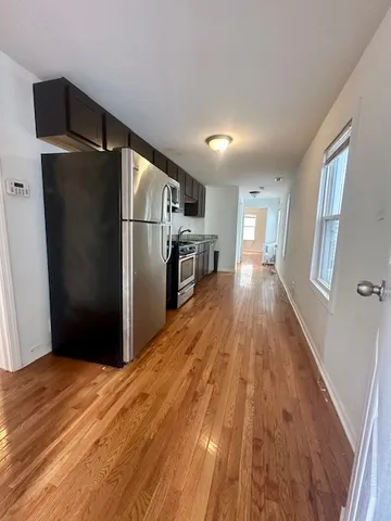 a kitchen with granite countertop a refrigerator and a sink