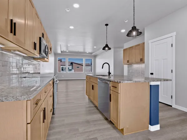 a kitchen with stainless steel appliances granite countertop a sink stove and cabinets