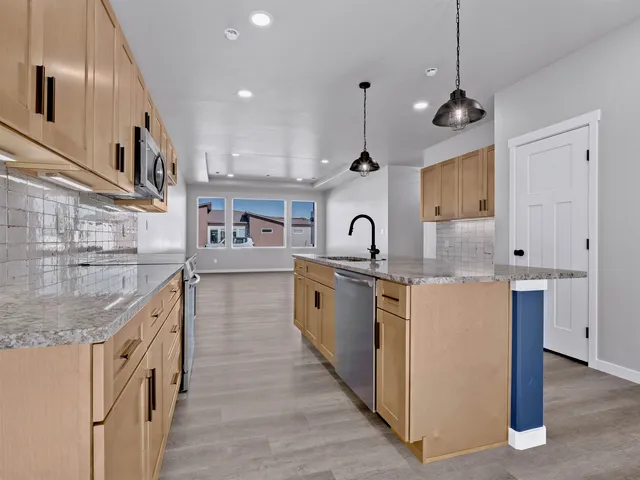 a kitchen with stainless steel appliances granite countertop a sink stove and cabinets