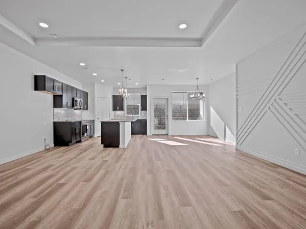 a view of a kitchen with a sink and an empty room