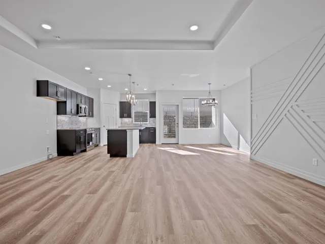 a view of a kitchen with a sink and an empty room