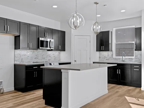 a large kitchen with stainless steel appliances granite countertop a sink refrigerator and microwave