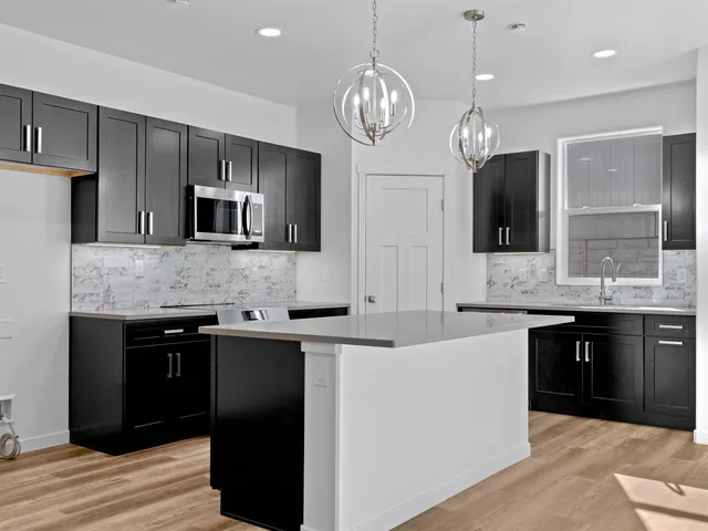 a large kitchen with stainless steel appliances granite countertop a sink refrigerator and microwave