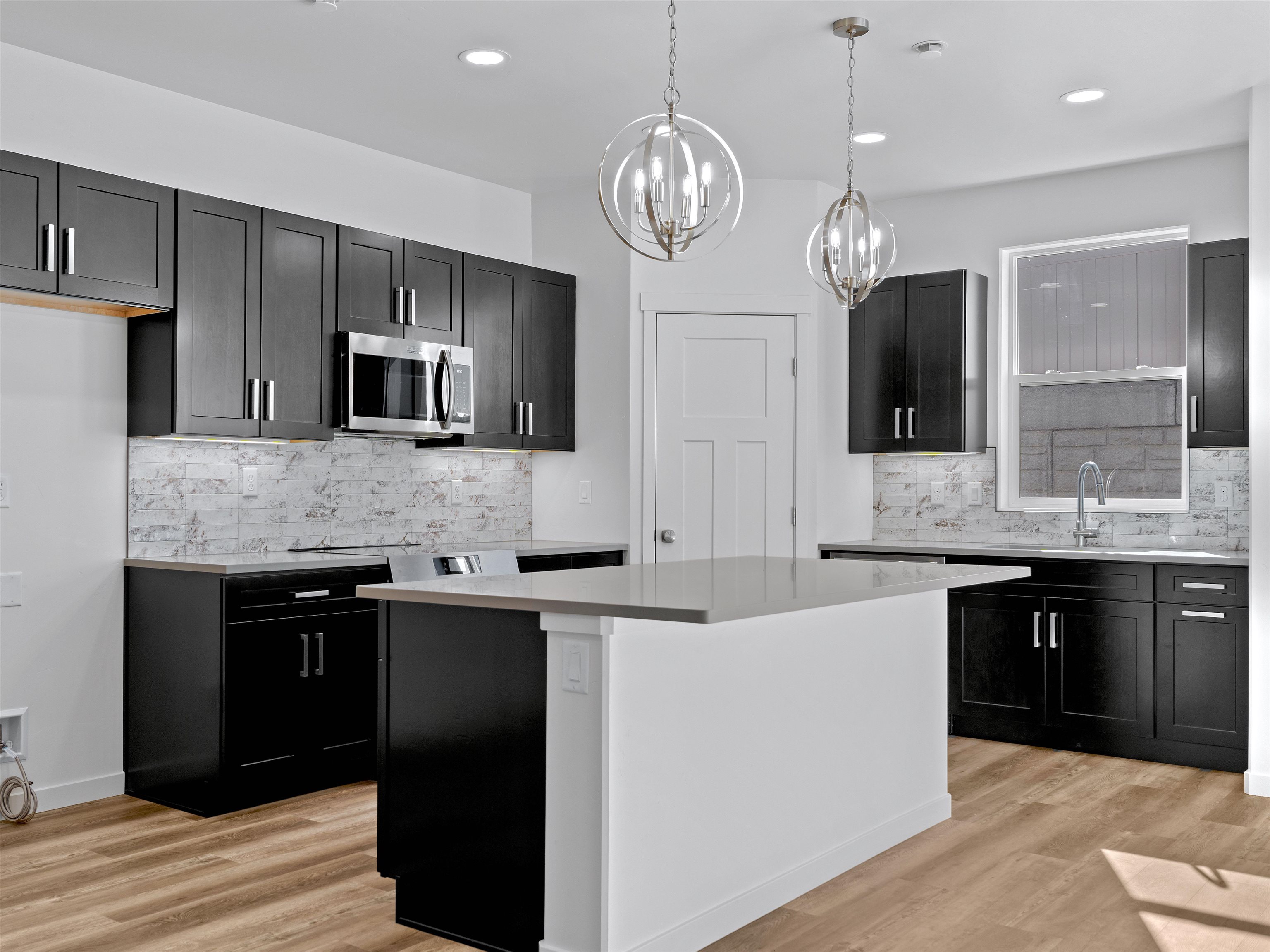 215 Shadow Mesa Street, Unit AND Grand Junction, CO 81503 - Photo 24 of 42 a large kitchen with stainless steel appliances granite countertop a sink refrigerator and microwave