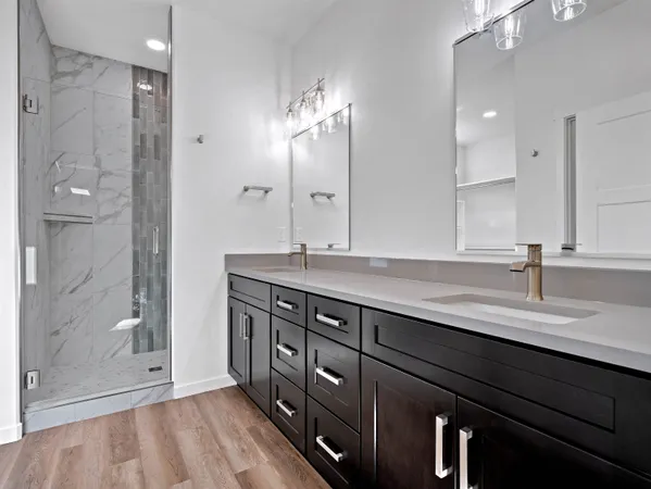 a bathroom with a granite countertop sink a large mirror and shower