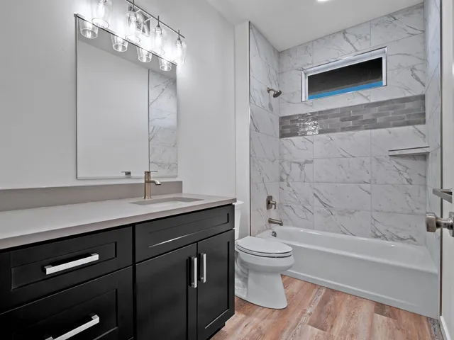 a bathroom with a sink a toilet a mirror and bathtub