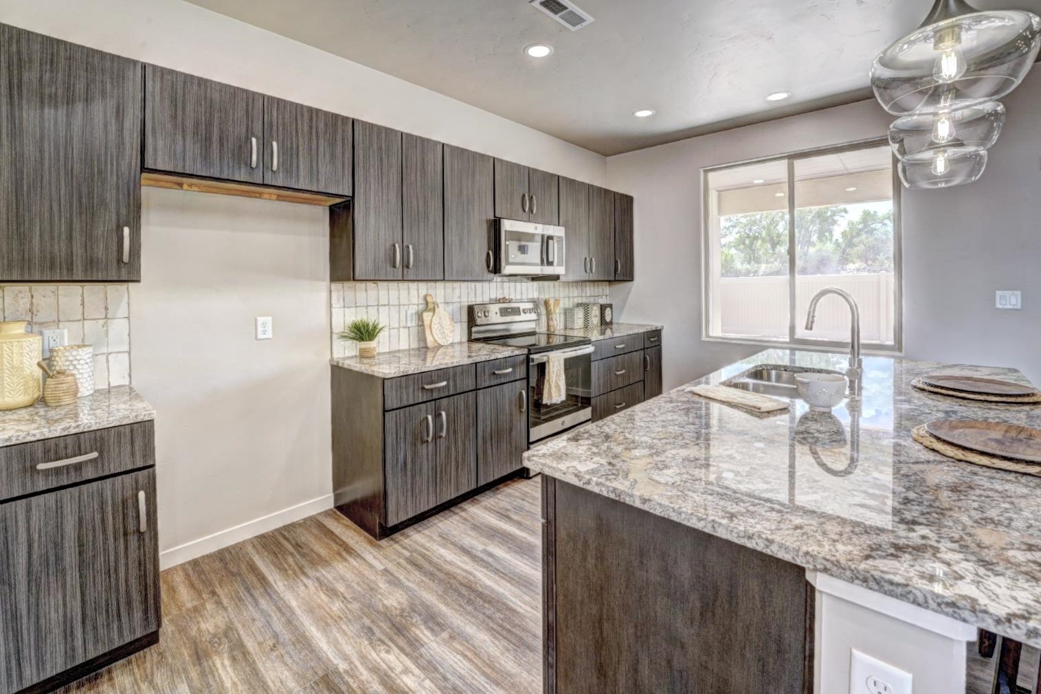 215 Shadow Mesa Street, Unit AND Grand Junction, CO 81503 - Photo 3 of 42 a kitchen with stainless steel appliances granite countertop a sink stove and refrigerator