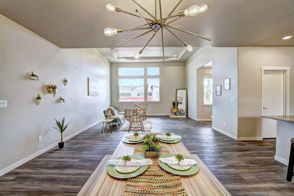 a view of a dining room with furniture a chandelier and wooden floor
