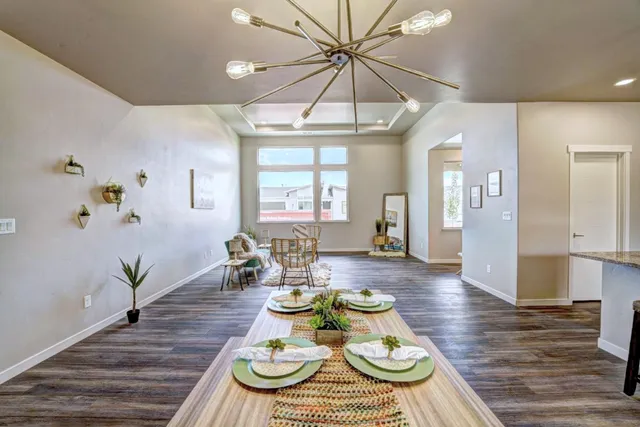 a view of a dining room with furniture a chandelier and wooden floor