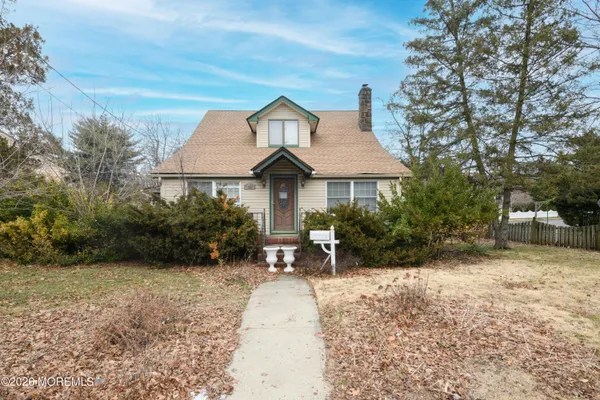a backyard of a house with table and chairs under an umbrella