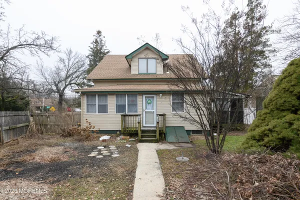 a front view of a house with a garden and trees