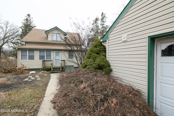 a view of a white house with a large trees