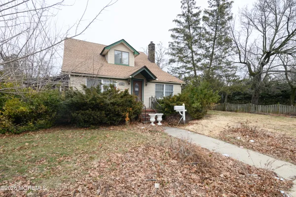 a view of a house with a yard and large tree