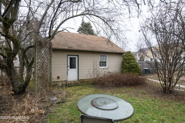 a backyard of house with barbeque grill and a large tree