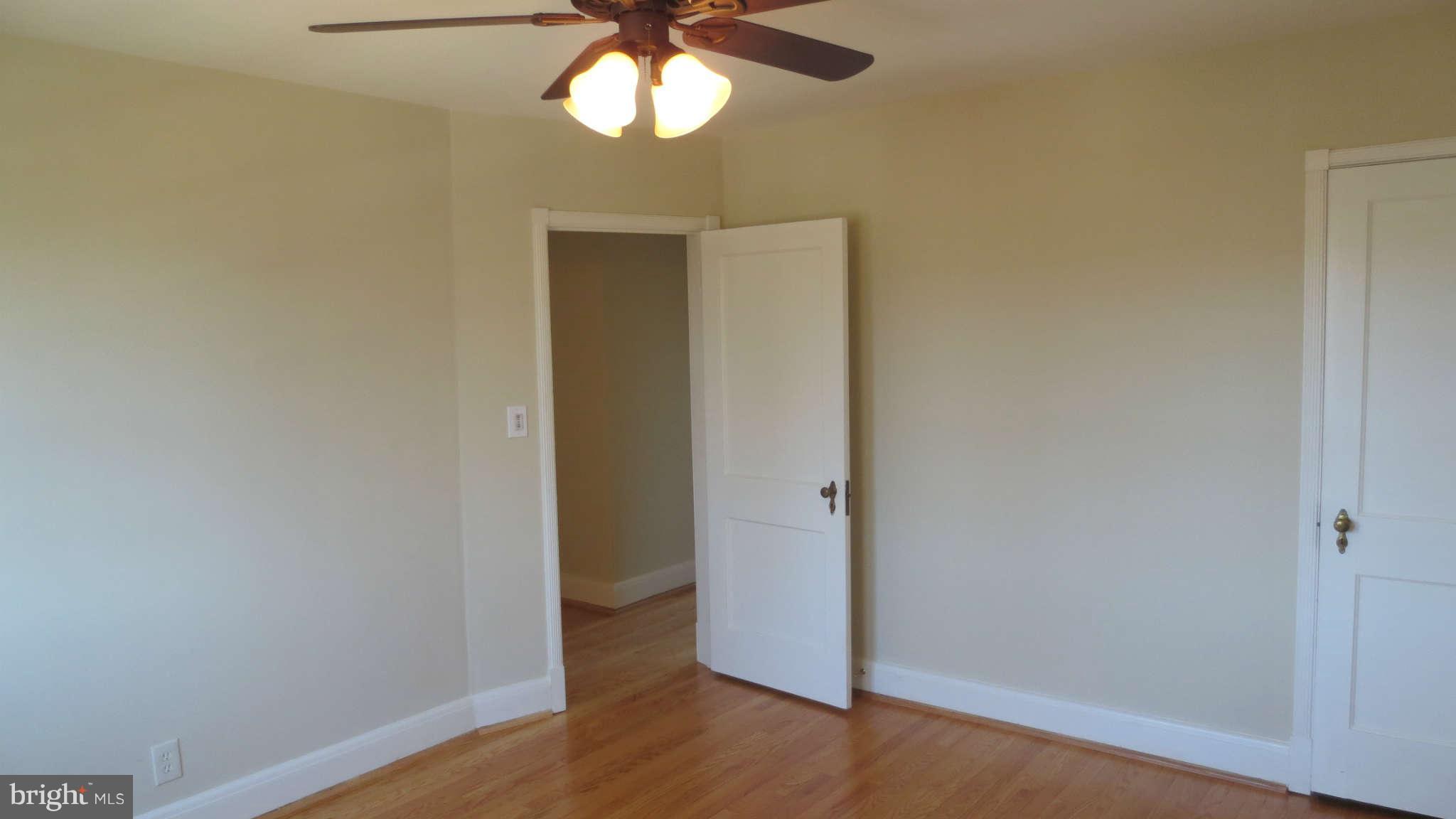 63 Murdock Road Baltimore, MD 21212 - Photo 11 of 16 an empty room with wooden floor fan and windows