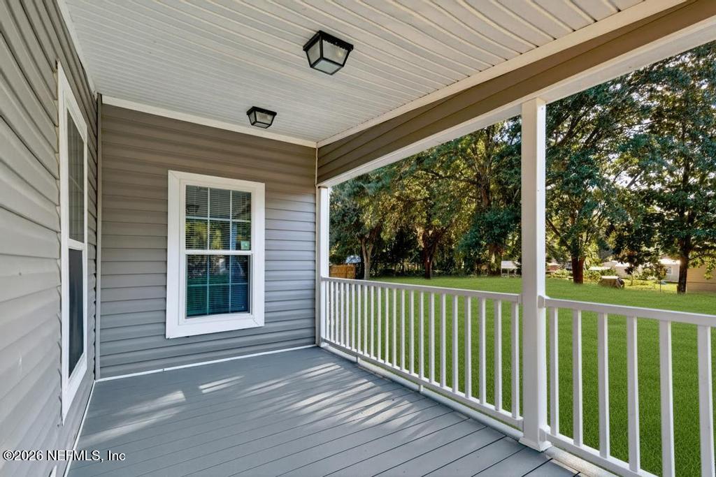 85146 Eady Lane Yulee, FL 32097 - Photo 13 of 74 a view of a porch with wooden floor and fence