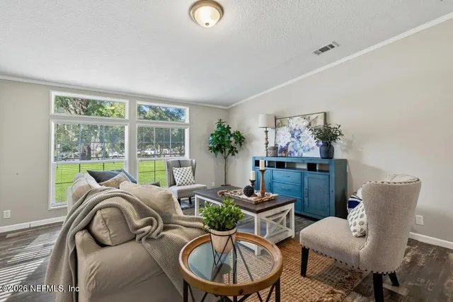 a living room with furniture and a dining table with kitchen view