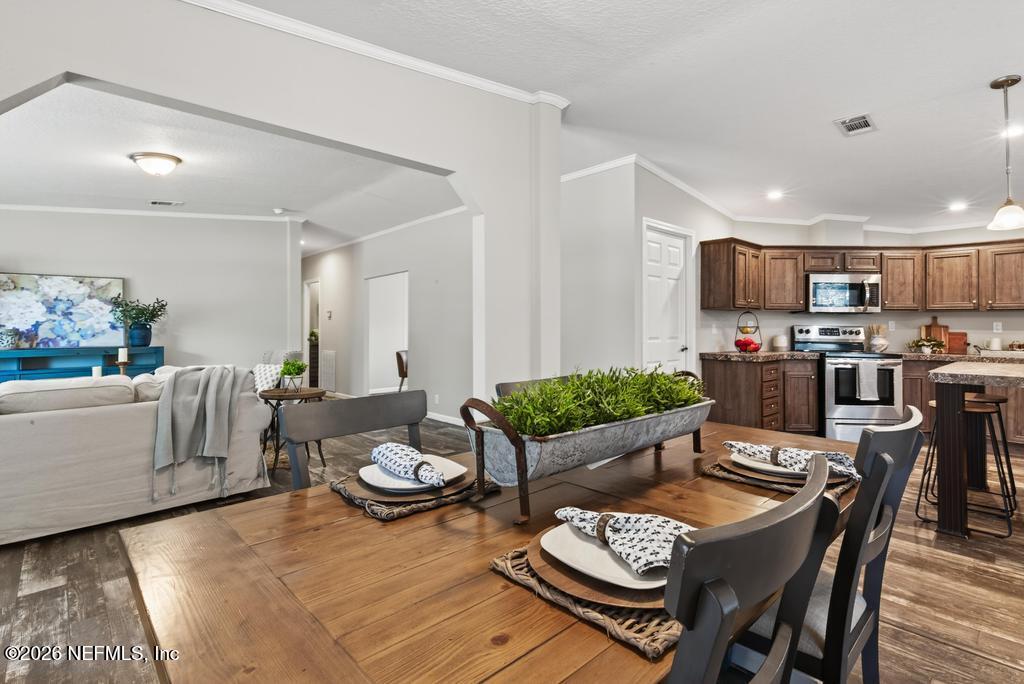 85146 Eady Lane Yulee, FL 32097 - Photo 23 of 74 a living room with furniture and a dining table with kitchen view