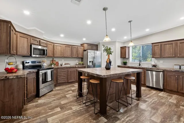a kitchen with stainless steel appliances granite countertop a sink stove and microwave