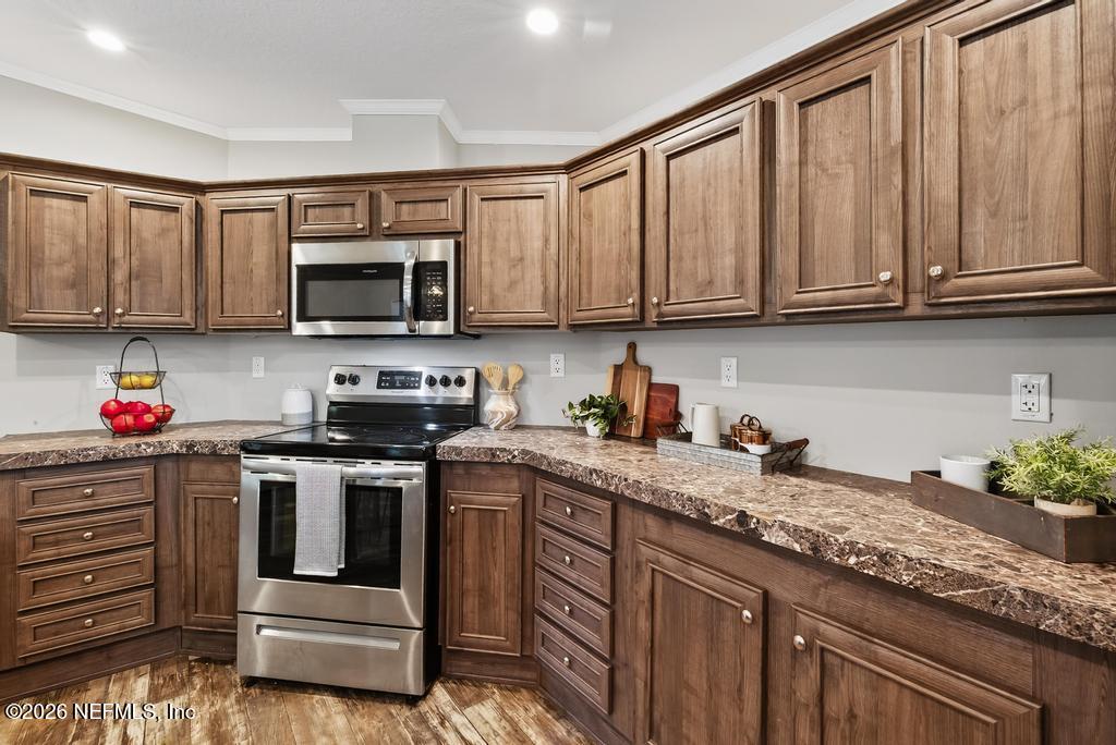 85146 Eady Lane Yulee, FL 32097 - Photo 27 of 74 a kitchen with granite countertop a stove top oven microwave and cabinets