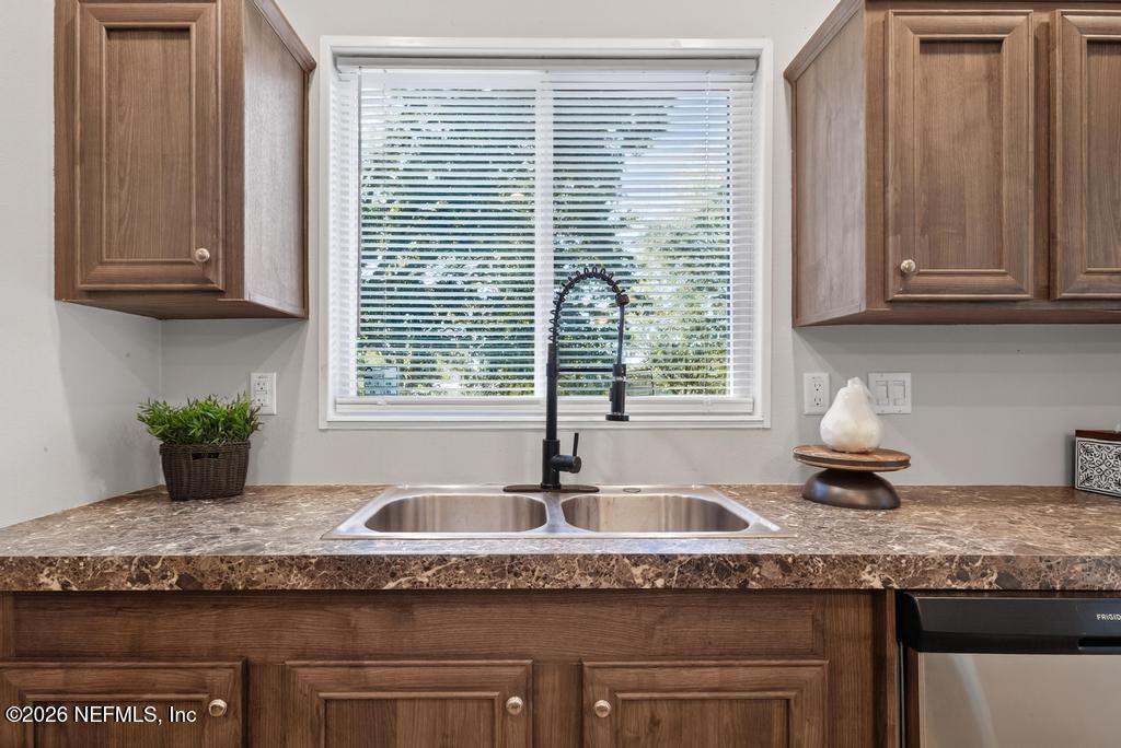 85146 Eady Lane Yulee, FL 32097 - Photo 29 of 74 a kitchen with granite countertop a sink and a white wooden cabinets