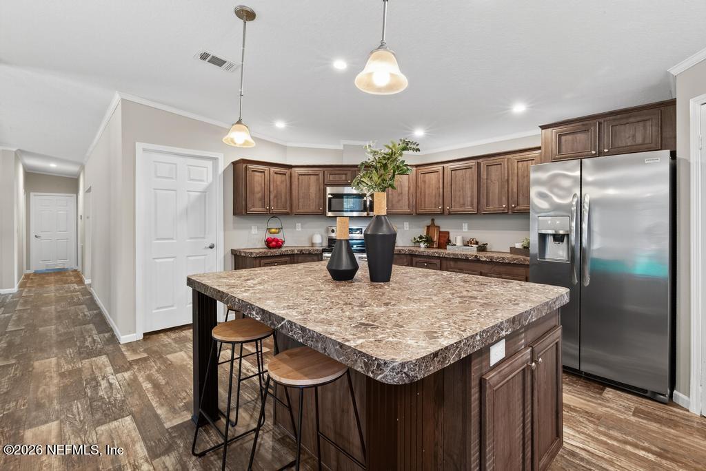 85146 Eady Lane Yulee, FL 32097 - Photo 30 of 74 a kitchen with stainless steel appliances granite countertop a sink refrigerator and microwave
