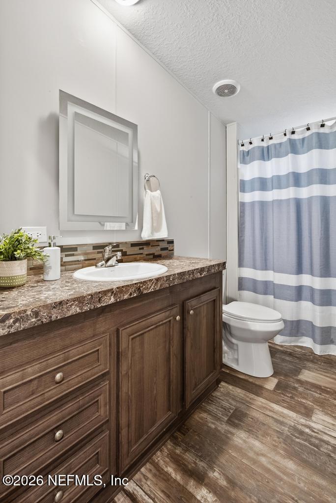 85146 Eady Lane Yulee, FL 32097 - Photo 36 of 74 a bathroom with a granite countertop sink and a toilet